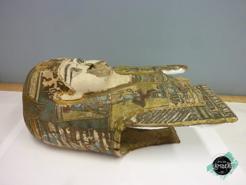 Photographie de l'oeuvre Masque de momie, de Artisan égyptien. Nature de l'intervention: Refixage et nettoyage de la couche picturale. Remise en forme.